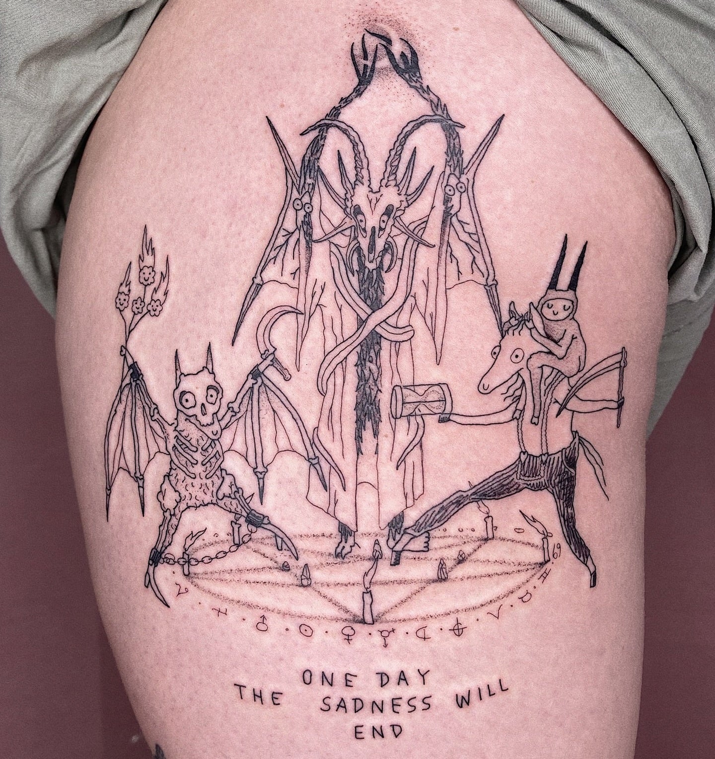 Tattoo of three winged creatures with a central figure holding an axe on a person's leg, with the text 'One day the sadness will end' below.